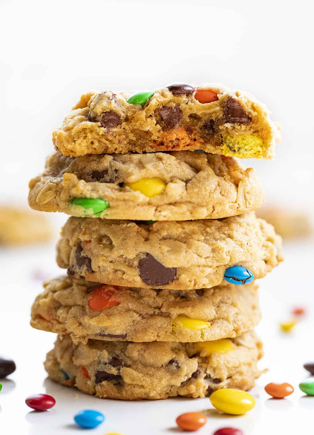 Soft Batch Monster Cookies are a cross between a soft peanut butter cookie and an oatmeal cookie that is loaded with peanut butter, oats, M&M's, and chocolate chips. Cookies, Baking, Monster Cookies, M&M Cookies, Cookie Recipes, i am baker, iambaker, dessert Stack of Soft Batch Monster Cookies