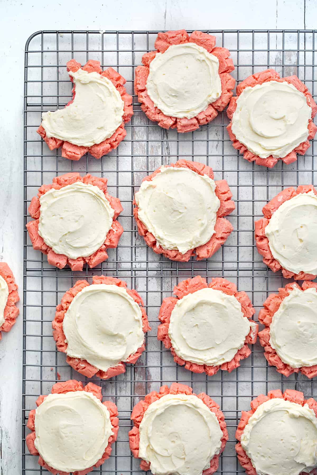 Pink Velvet Sugar Cookies with Vanilla Meringue are soft sugar cookies tinted to a light pink color and frosted with an easy, velvety Swiss Meringue buttercream. Pink Velvet Sugar Cookies with Easy Swiss Meringue on a Cooling Rack.