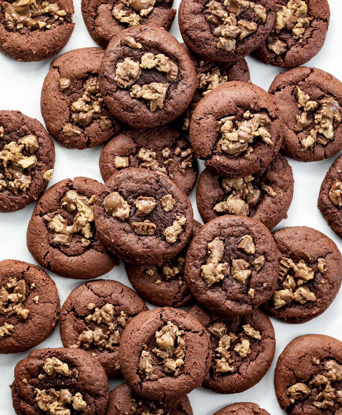 Chocolate Reese's Cake Mix Cookies are cookies made with chocolate cake mix and topped with chopped mini Reese's peanut butter cups. I love from-scratch cookies (there are hundreds on my website!) but also love the convenience of grabbing a cake mix! Reese's Cake Mix Cookies on a White Counter Shot from Overhead.