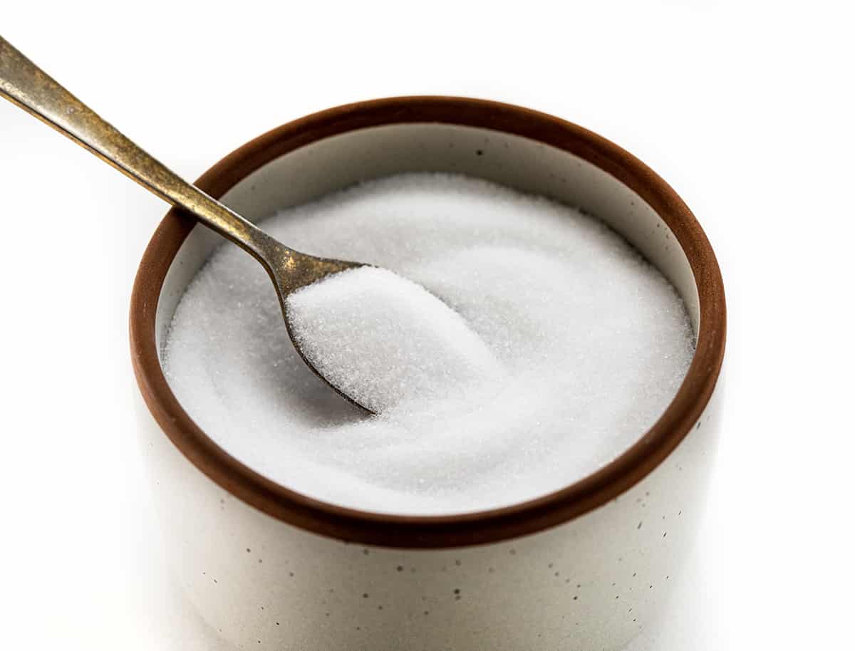 I often get asked about the role of salt in baking, especially kosher as that is what I prefer. Salt is not just a flavor enhancer, but it also plays a vital role in the baking process. In fact, it's one of the four essential ingredients in bread - flour, salt, yeast, and water. I'd love to share which salt I use, and why different salts can't be used interchangeably! A Container of Table Salt with a Spoon in it.