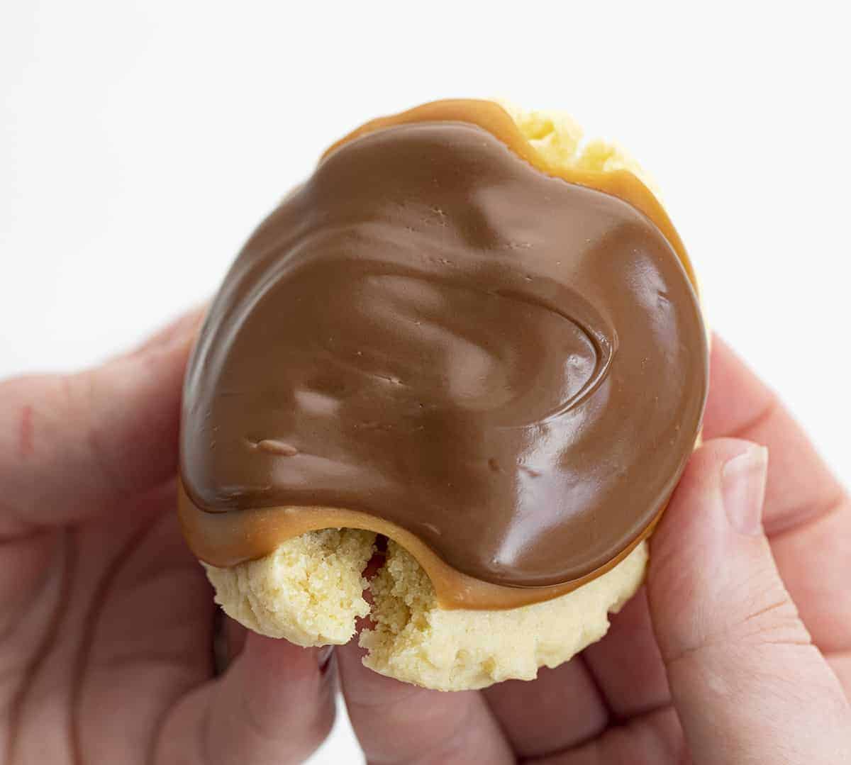 Twix Cookies are large, soft butter cookies topped with caramel sauce and melted milk chocolate. These cookies are like eating a Twix candy bar... but in cookie form! The super-soft cookies are topped with "homemade" caramel and milk chocolate, just like the famous candy bar. Baking, Cookies, Cookie Recipes, Dessert, Caramel Cookies, Caramel Recipe, Milk Chocolate, Kid Approved Snacks, i am baker, iambaker Hand Breaking Apart a Twix Inspired Cookie