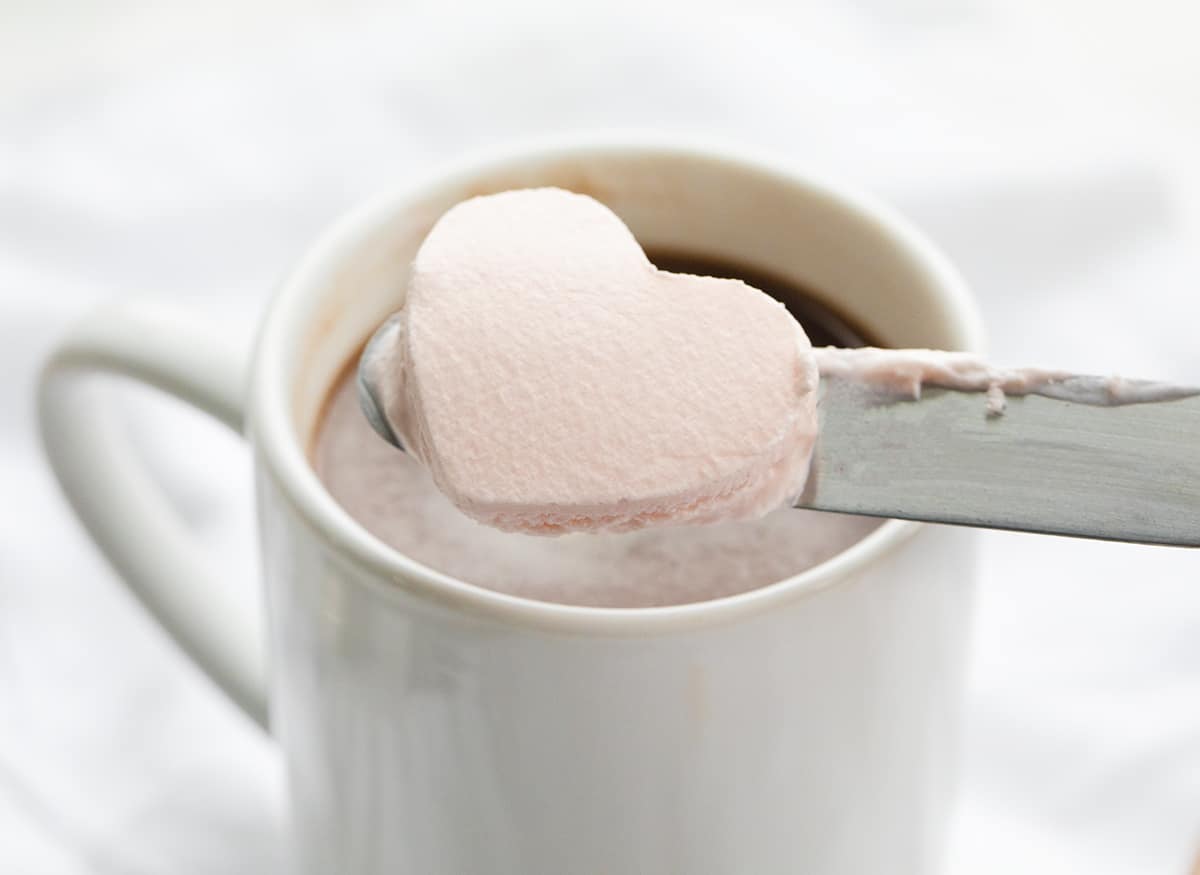 Whipped Cream Hearts are made with a homemade whipped topping that has been frozen and cut into heart shapes. Whipped Cream Hearts, Valentines Day, Dessert, Frozen Whipped Cream for Hot Chocolate, Frozen Whipped Cream, homemade whipped cream, i am baker, iambaker, recipes, hot chocolate, hot cocoa ideas Whipped Cream Heart Being Added to Hot Chocolate